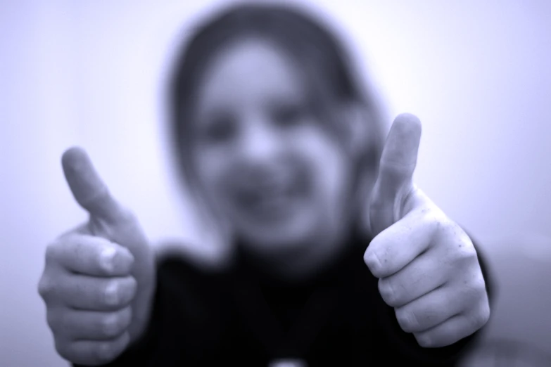 a woman pointing to the camera and giving thumbs up