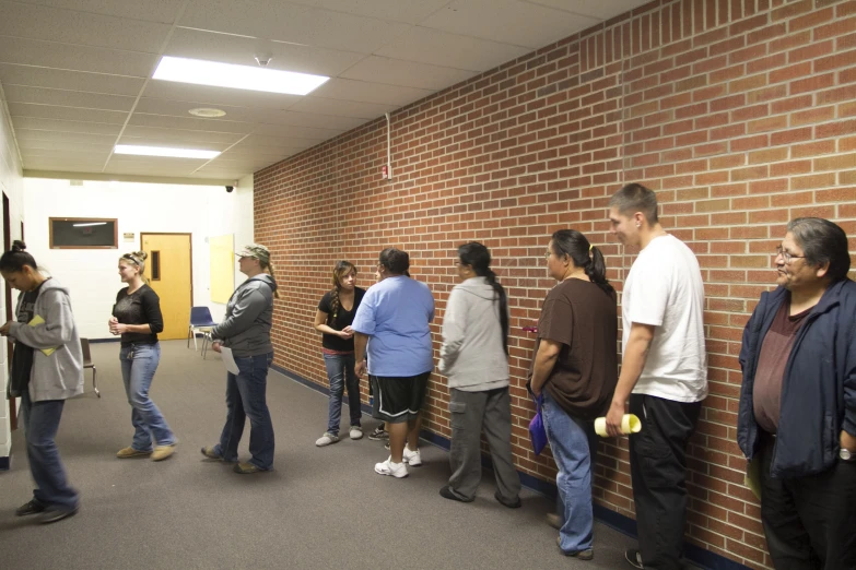 a bunch of people that are standing in a line by some bricks