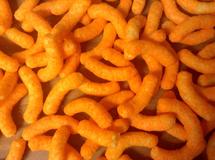 large group of cut up cheetos sitting together on a table