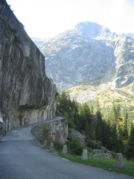 a very steep road leading into the distance to some big mountains