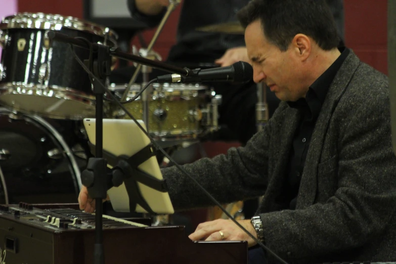 a man that is sitting in front of a microphone