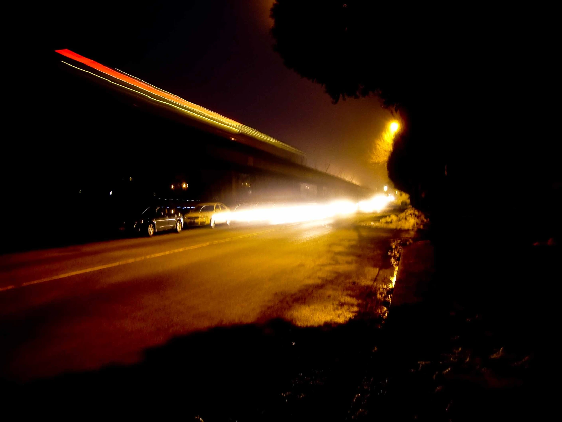 cars and traffic moving at night on a residential street