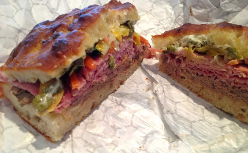 a cut in half sandwich is displayed on wax paper