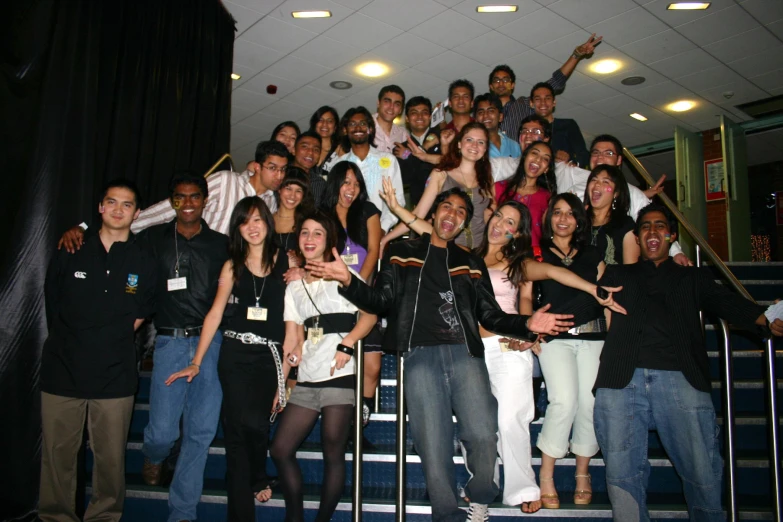 a group of people stand behind a stairwell railing while one looks up