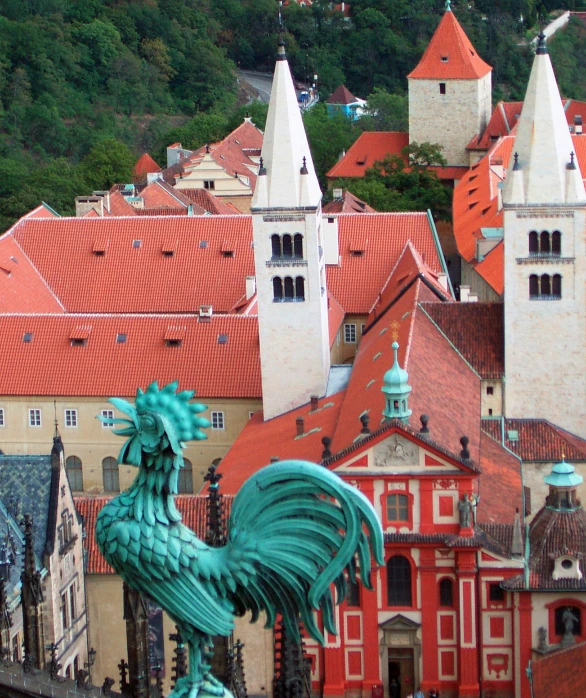 an image of a rooster statue in the middle of town