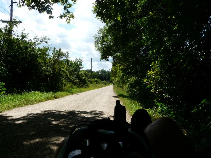 a street view of the road with lots of trees and grass on both sides of the street