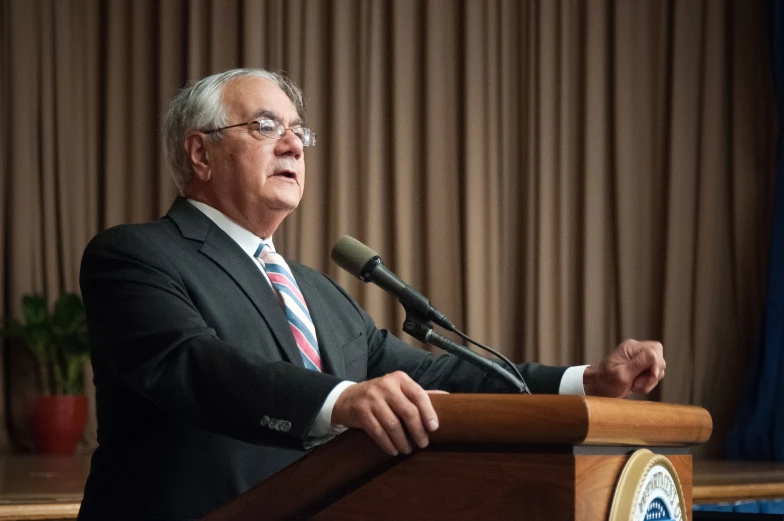 a man in a suit standing at a podium