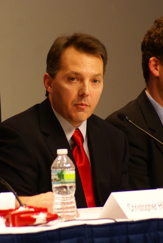 two men in suits at a press conference