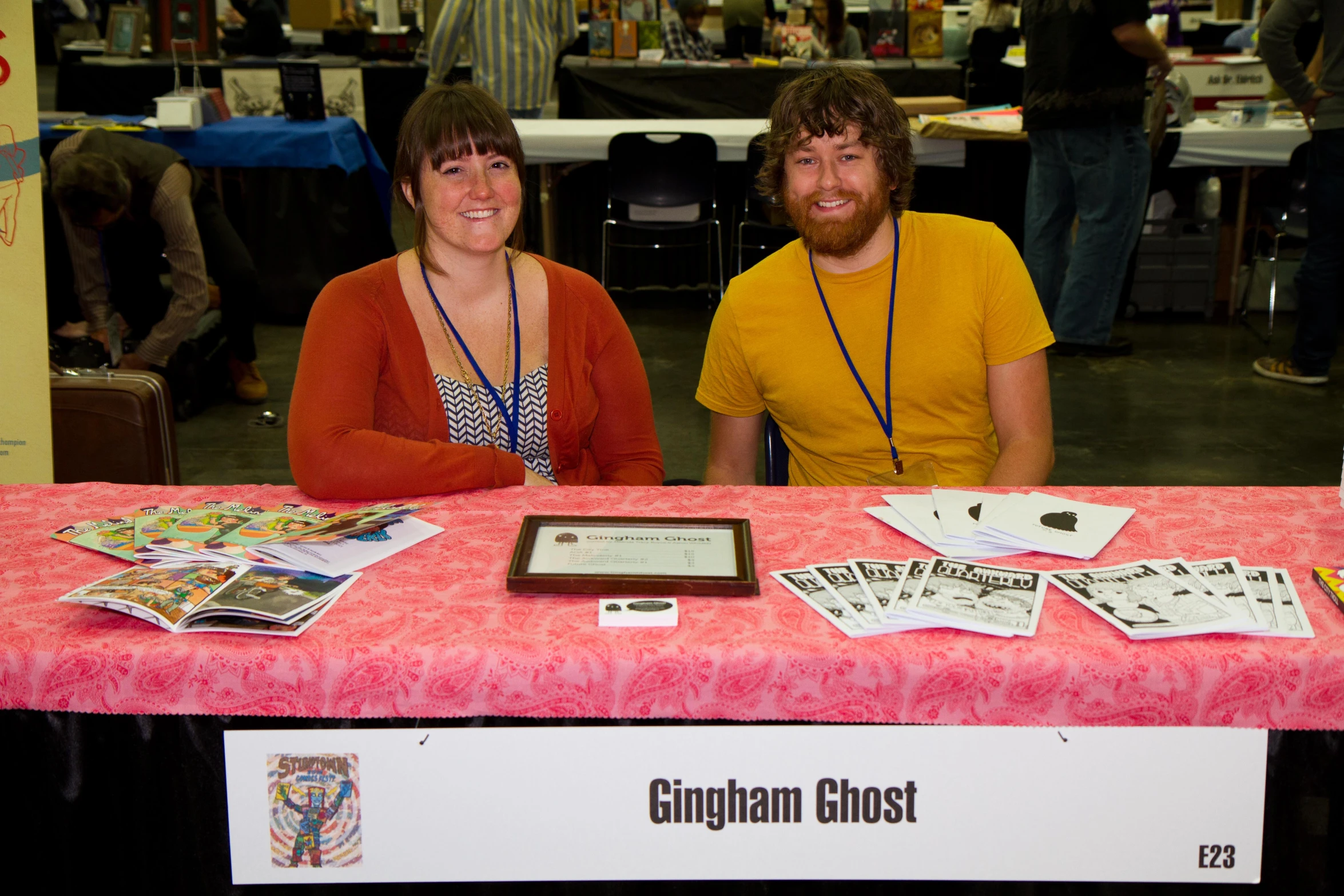 two people are sitting at a table with books and magazines