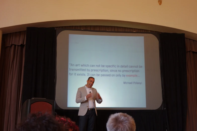 a man is giving a presentation on the slide screen