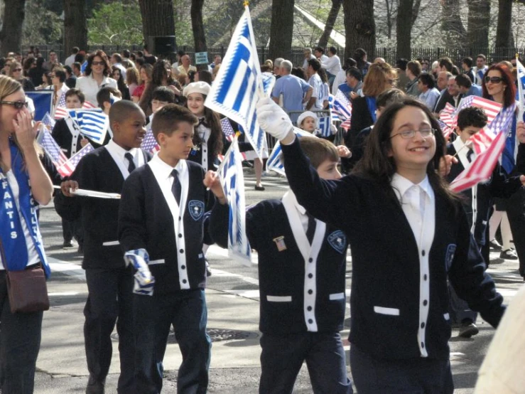 s are walking in the street while carrying flags