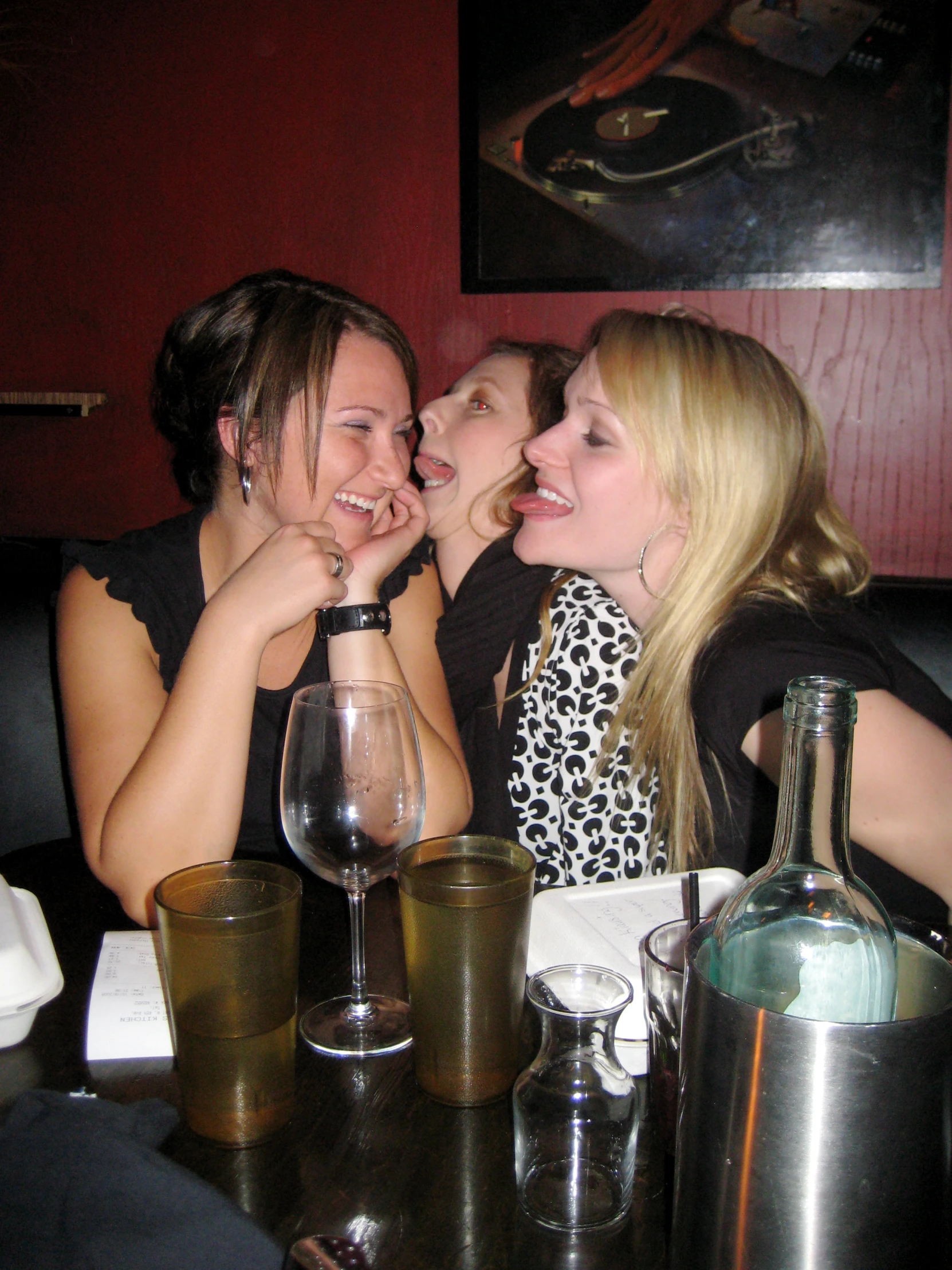 a group of women sitting at a table talking and smiling