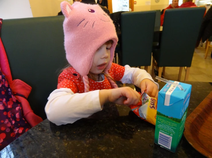 a little girl that is sitting at a table