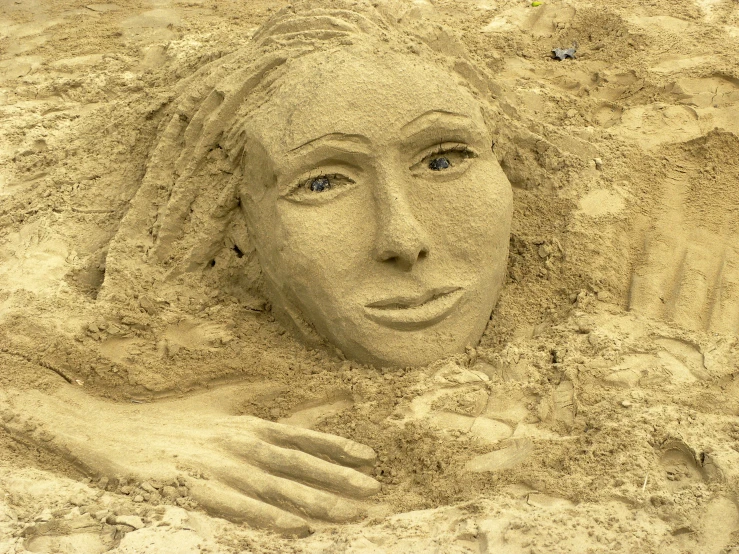 a sand face that is sticking out of the sand
