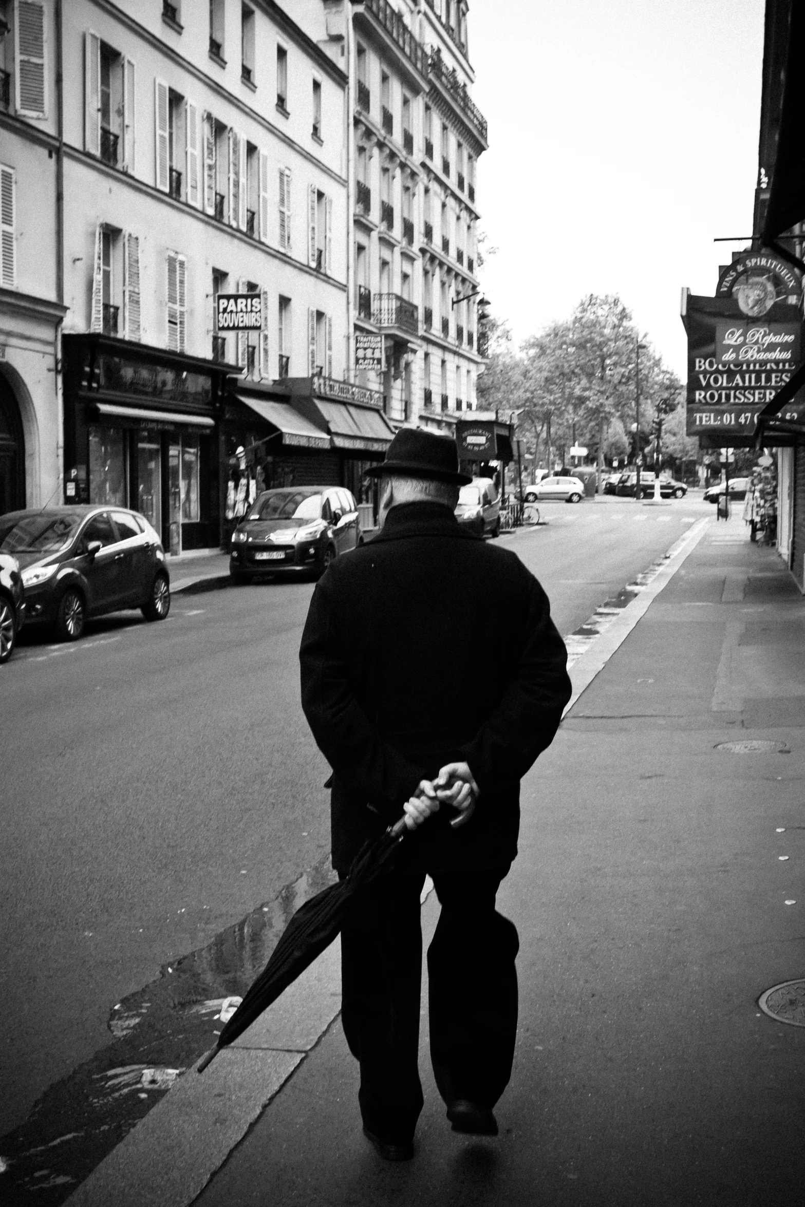 a man walking on the sidewalk of a city street