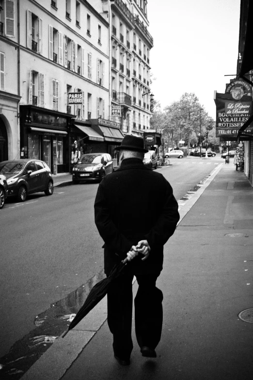 a man walking on the sidewalk of a city street
