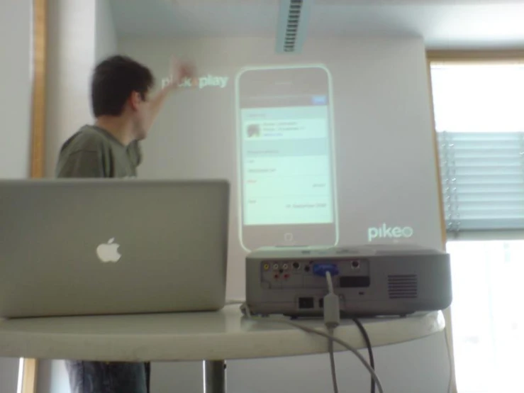 a man is standing at his desk using his laptop