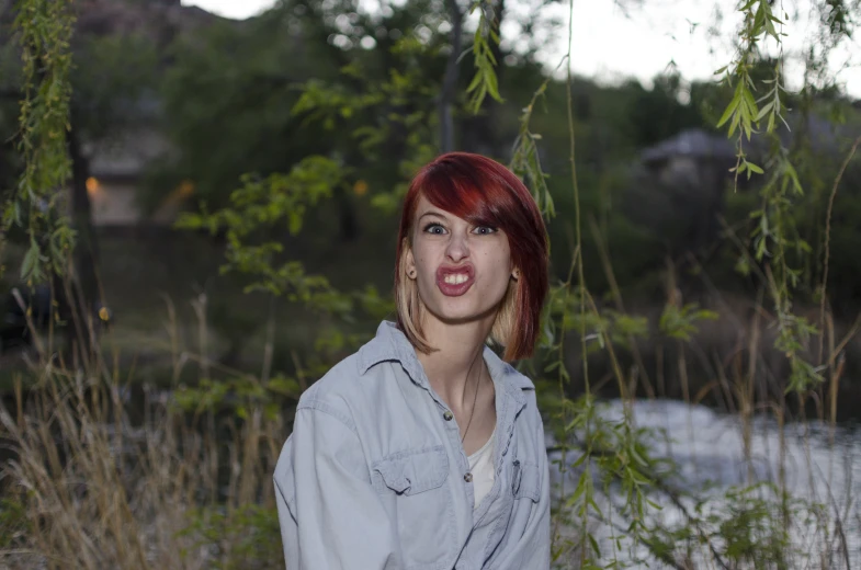 a woman posing for a picture in a grassy field