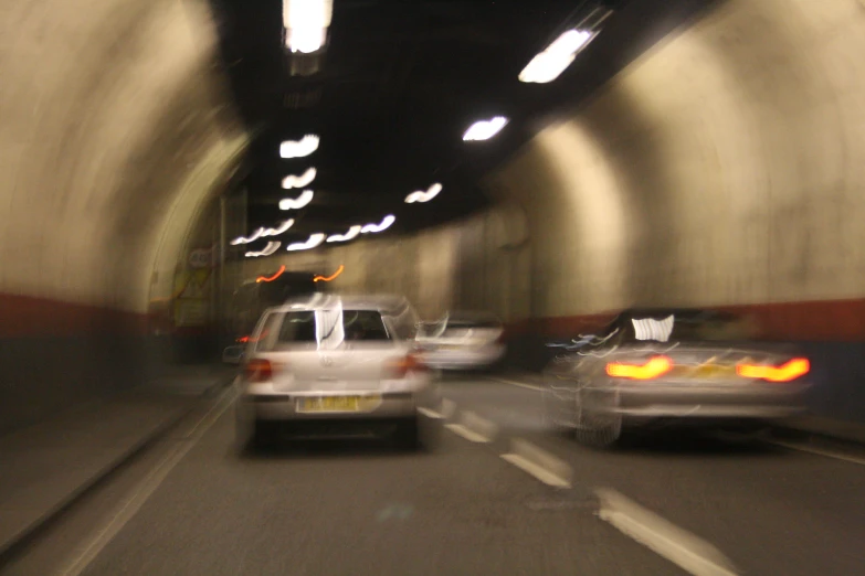 two cars driving through a tunnel next to each other