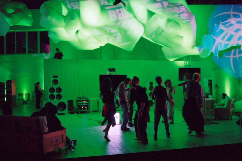 people dancing on the stage with green light