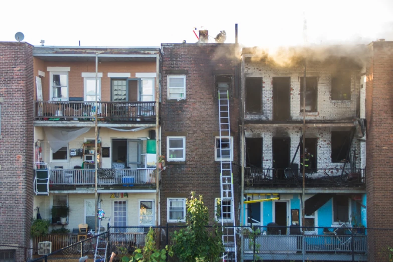 smoke billows from the ceiling of the apartment building