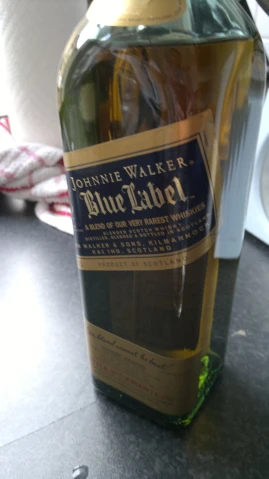 a bottle with the label blue label is on a table