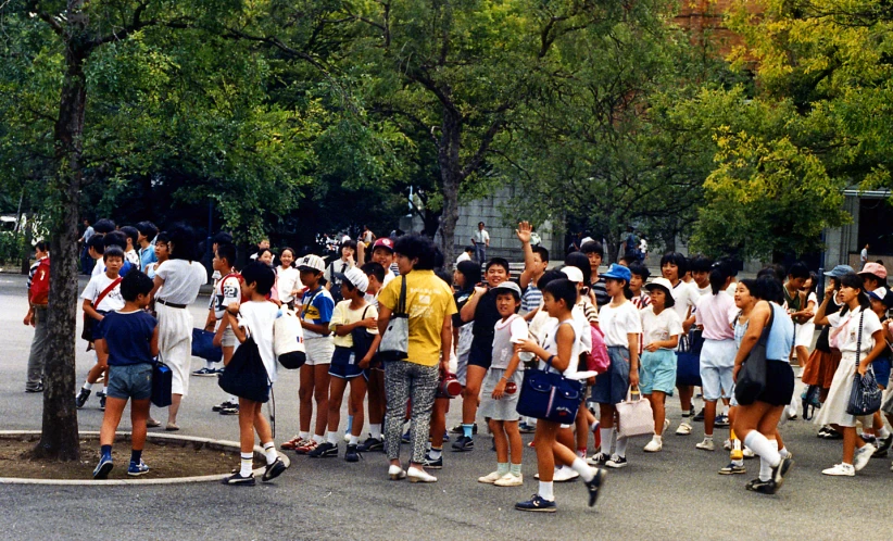 a large group of people walking around a park