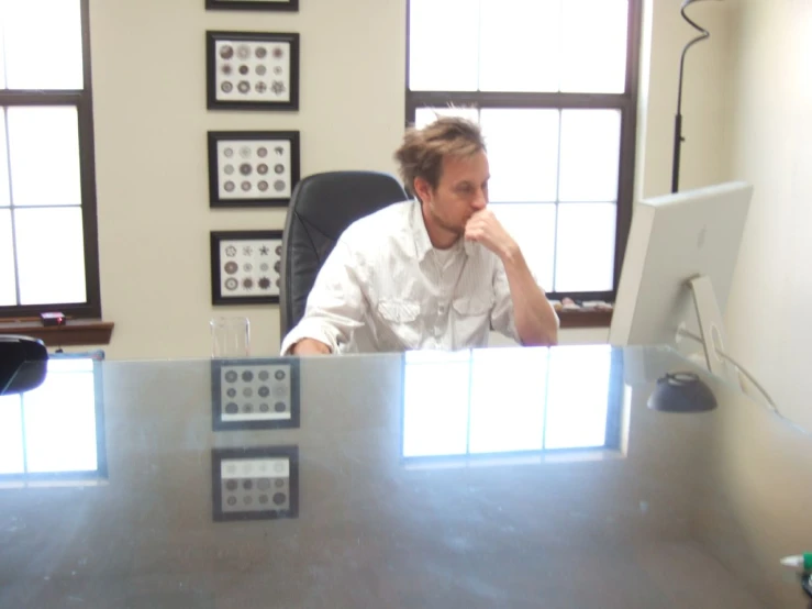 a man is sitting at his desk with his computer