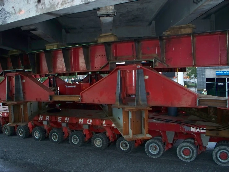 a red tractor trailer under an overpass