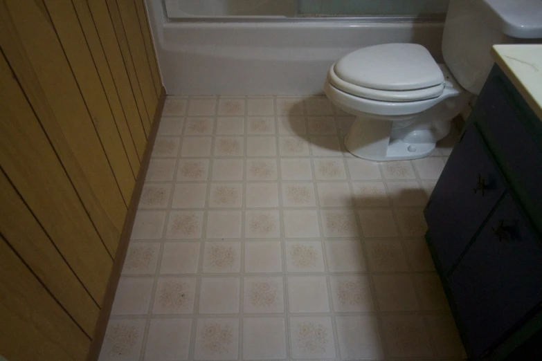 the small bathroom has yellow wood and white tile