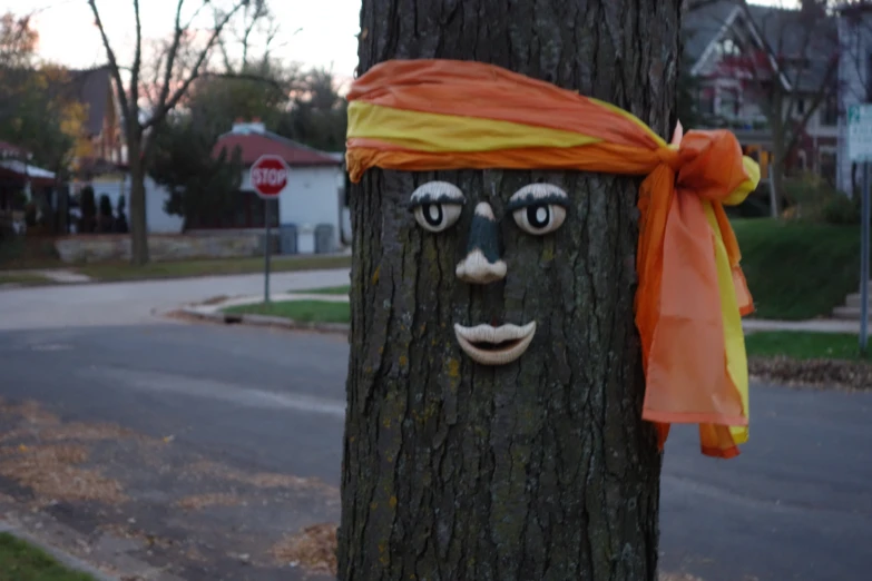 a wooden mask on the side of a tree