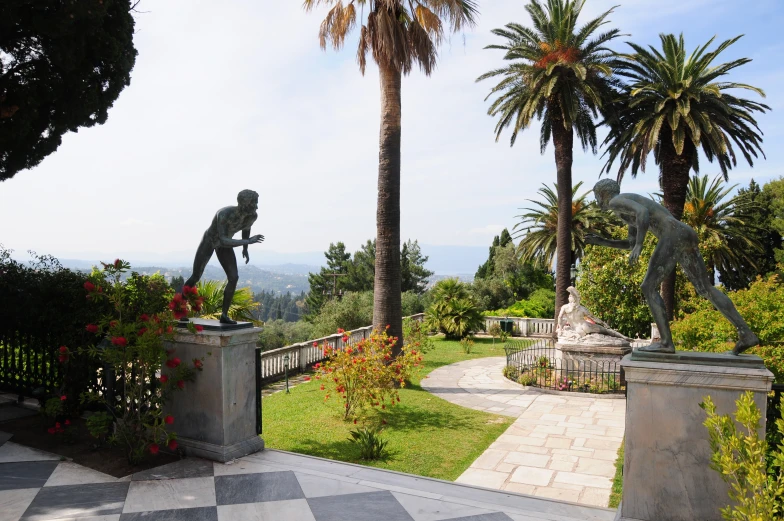 the sculpture is located near a park of flowers and palm trees