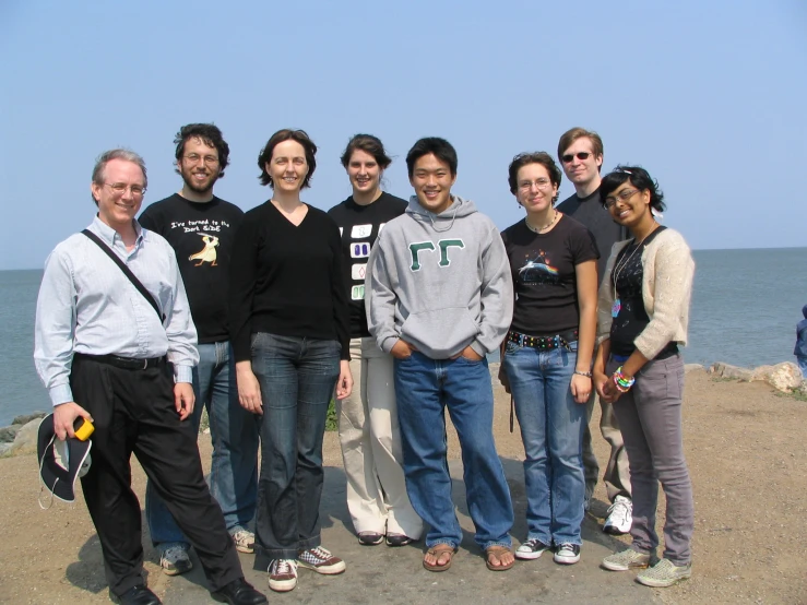 a group of people standing together in front of water