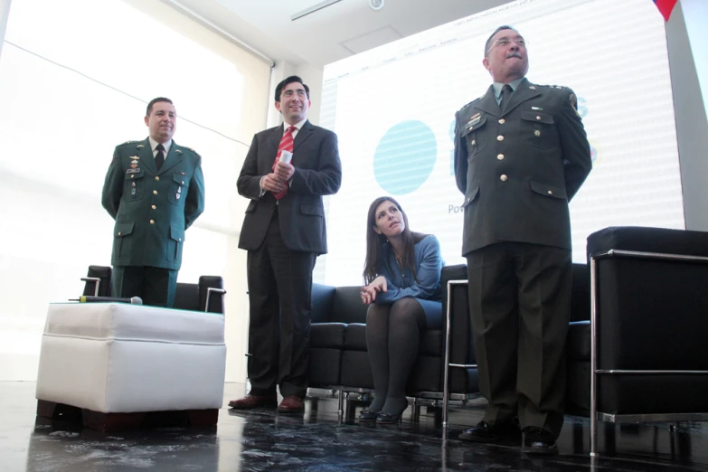 four people standing in front of a large screen