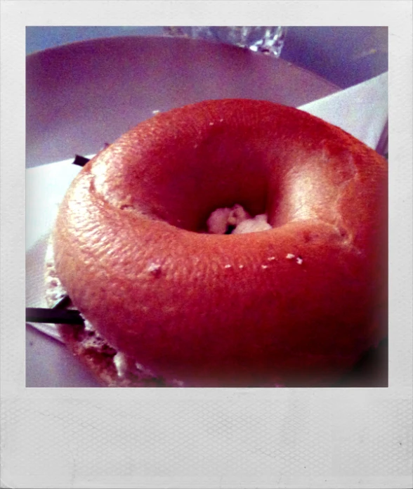 an orange doughnut on top of a white plate