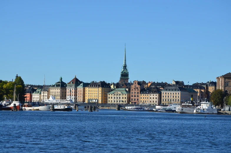 many buildings on the shore and one large building with spire