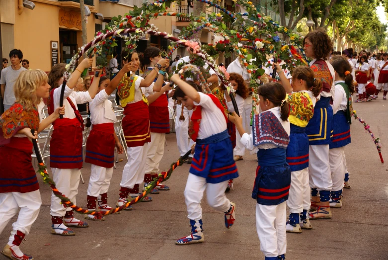 children perform on the street in colorful costumes