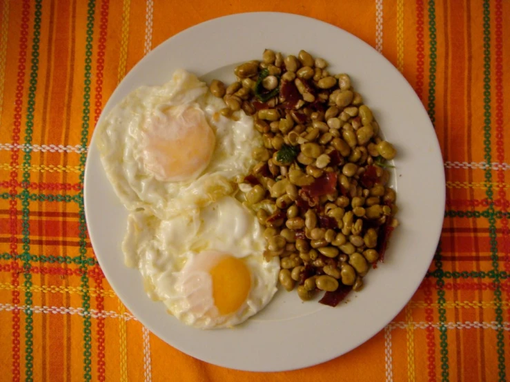 an egg, bacon, and bean meal on a plate