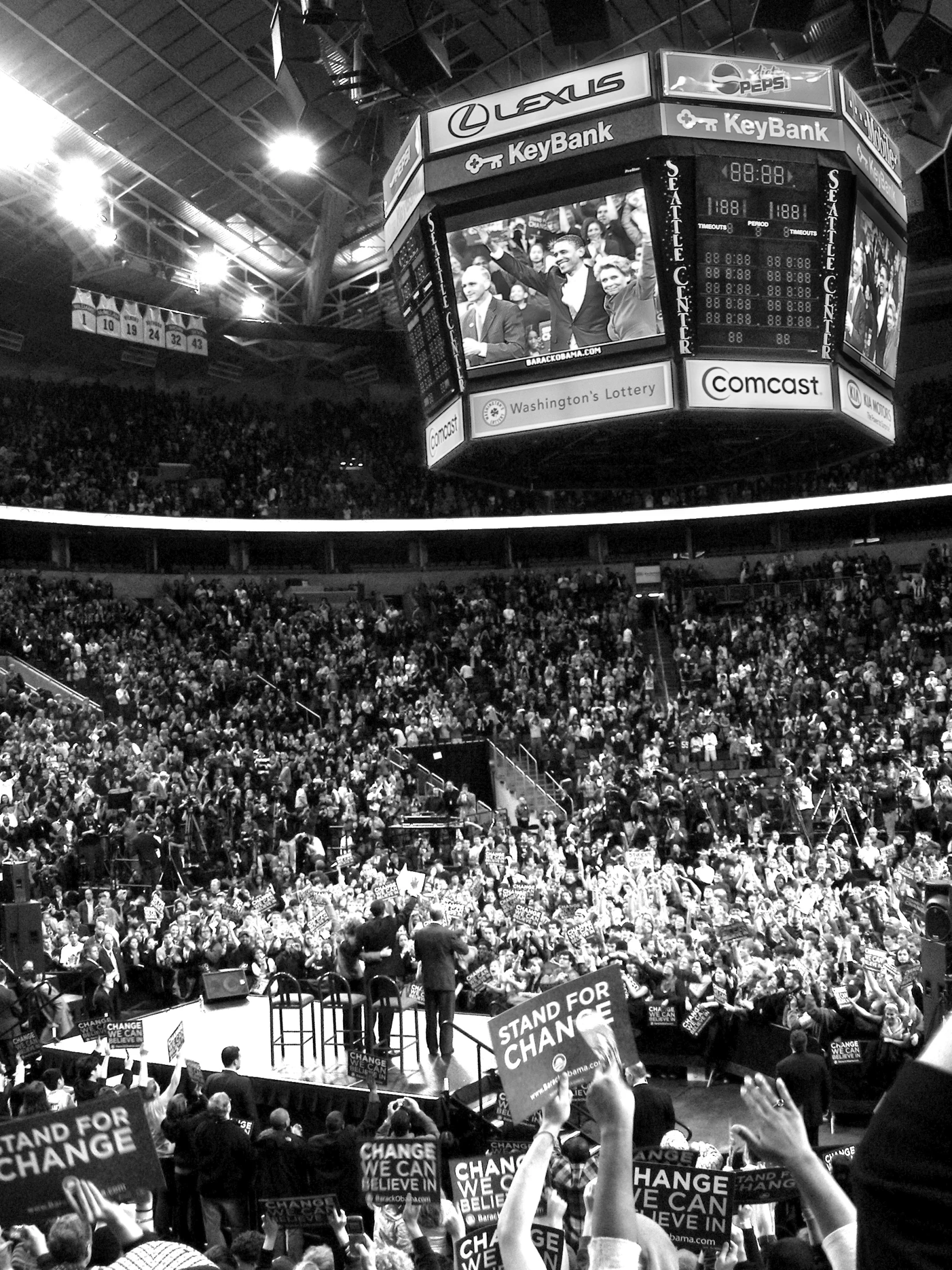 a crowd of people standing around a gym watching a game