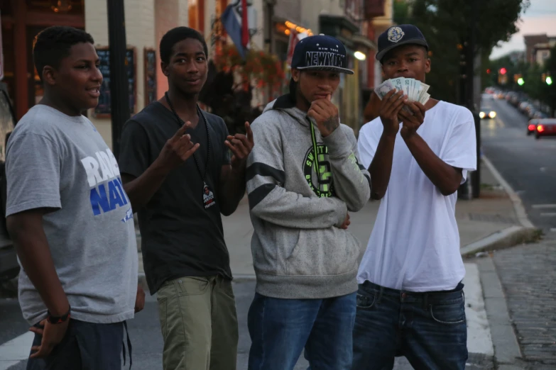 four boys standing on the street holding soing in their hands