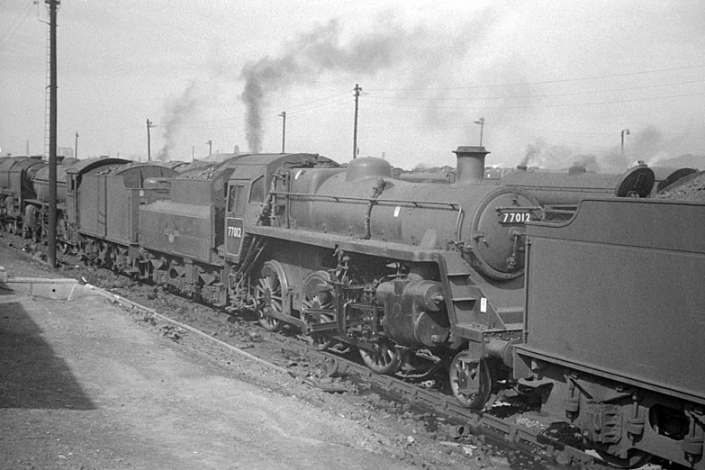 an old time steam train pulling cars on tracks