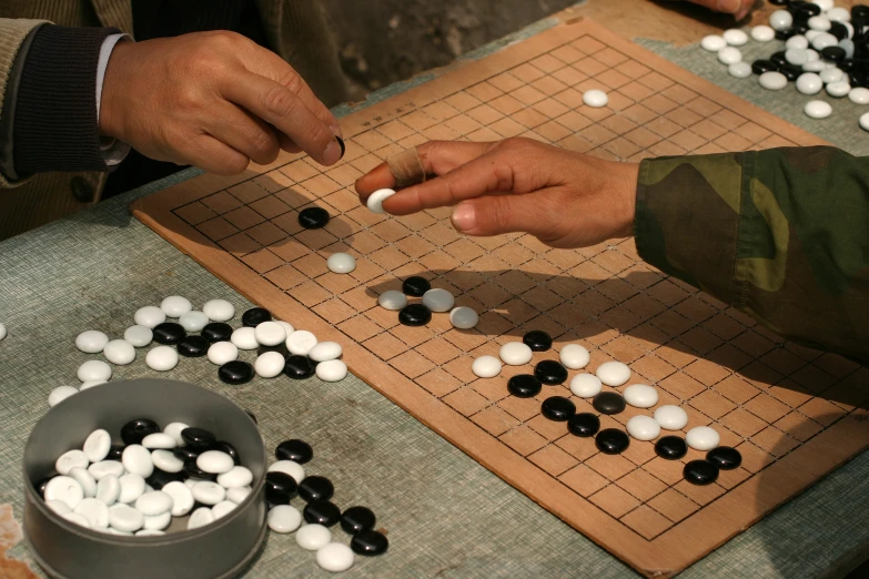 two people play go on the board game