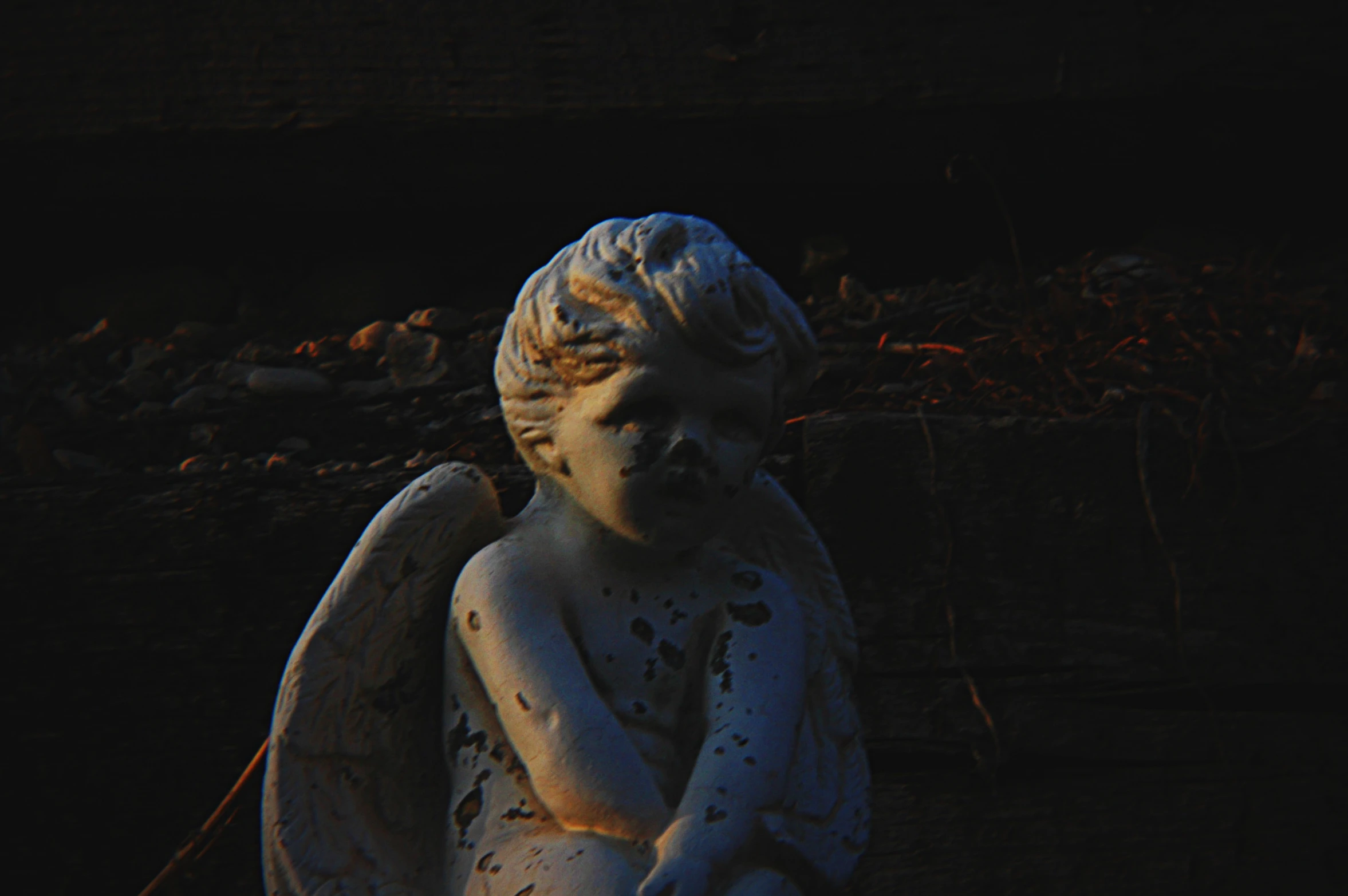 an angel statue sitting next to some logs