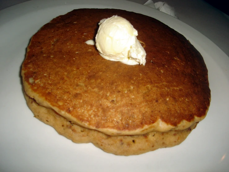 a plate with three pancakes on it with a scoop of ice cream