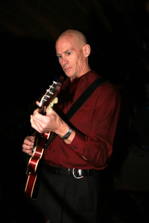 a person playing an acoustic guitar on a stage