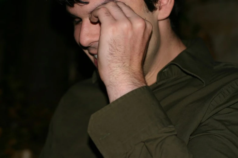 a man holds his hands to his face and smiles