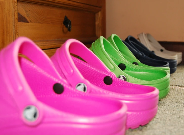 a group of shoes lined up in line against a wall