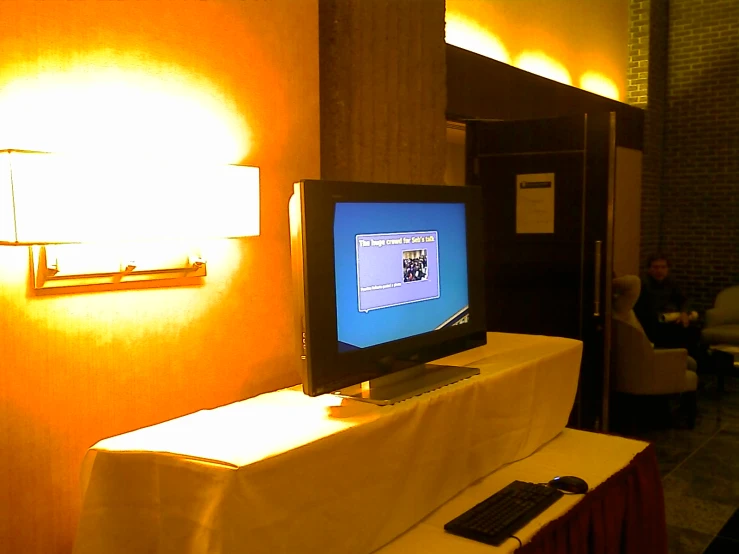 a small tv sitting on a small desk in front of a light