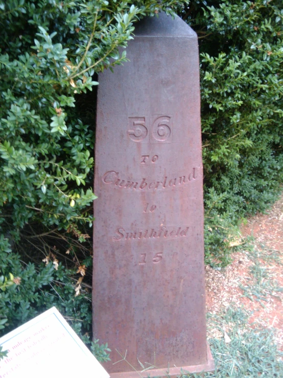 an old obelisk stands in the grass outside