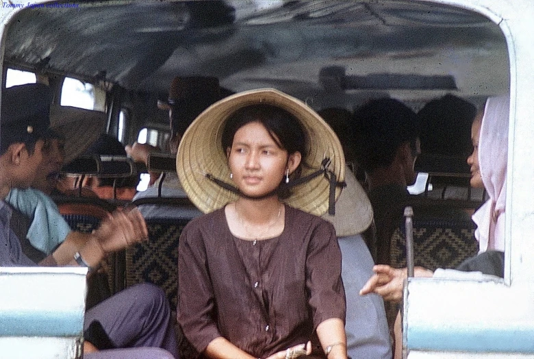 women are sitting in a boat with a straw hat on her head